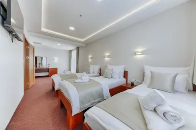 a hotel room with two beds and a bathroom at Casa Costa in Dobra Voda
