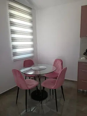a table and four pink chairs in a room at Luna Apartment in Kotor