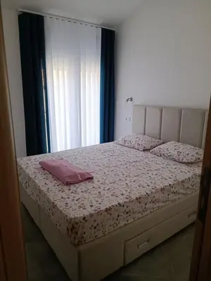 a bedroom with a bed with pink pillows on it at Luna Apartment in Kotor