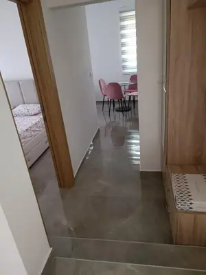 a hallway with a staircase leading to a room with a table at Luna Apartment in Kotor