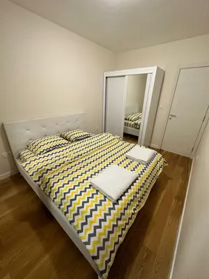 a large bed in a room with a mirror at Apartman VT 2 Central point in Podgorica