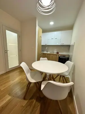 a kitchen with a white table and white chairs at Apartman VT 2 Central point in Podgorica