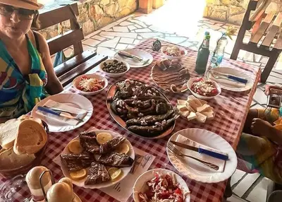 a woman sitting at a table with plates of food at Skadar Lake Apartment -Anja in Vranjina