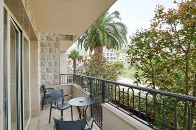 a balcony with two chairs and a palm tree at Apt 