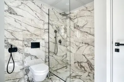 a bathroom with a toilet and a glass shower at Apt 