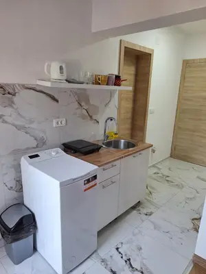 a white kitchen with a sink and a counter at Apartmani Seaview in Sutomore