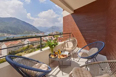 a balcony with chairs and a table with food on it at Condo Cattaro in Kotor