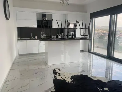 a kitchen with white cabinets and a large window at A. Montenegro in Dobra Voda
