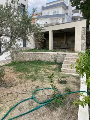 a garden with a hose in front of a house at A. Montenegro in Dobra Voda
