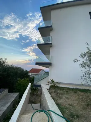 a house with a green hose on the side of a building at A. Montenegro in Dobra Voda