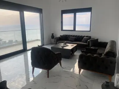 a living room with couches and a table and windows at A. Montenegro in Dobra Voda