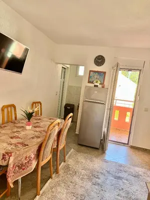 a dining room with a table and a refrigerator at Apartments Zeneva in Donji Štoj