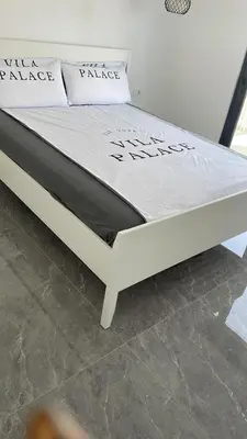 a bed in a room with a white bed frame at Vila Palace 4S next to Plaza in Donji Štoj