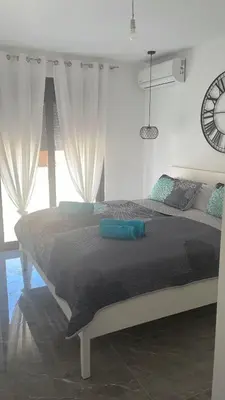 a bedroom with a large bed with blue pillows at Vila Palace 4S next to Plaza in Donji Štoj