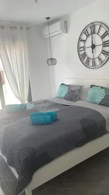 a bedroom with a large bed with a clock on the wall at Vila Palace 4S next to Plaza in Donji Štoj