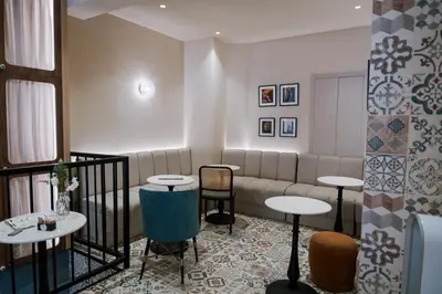 a waiting room with a couch and tables and chairs at Kondo Hotel Allure in Budva
