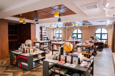 a library with tables filled with books at Kondo Hotel Allure in Budva