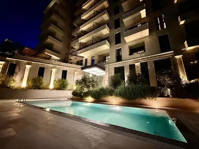 a swimming pool in front of a building at night at Casa Al Mare Lena Seaside in Budva