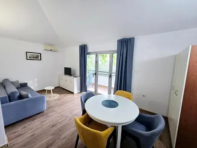 a living room with a table and chairs and a couch at Olive trees in Budva