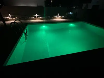 a swimming pool with green lighting in a dark room at Villa Tunaj new Pool and BBQ in Bar