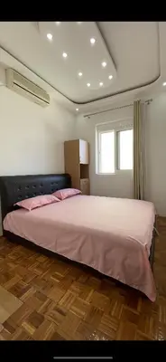 a bedroom with a large bed with pink sheets at Aprtmani centar 2 in Ulcinj