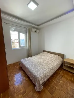 a bedroom with a bed and a window at Aprtmani centar 2 in Ulcinj