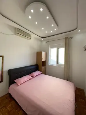 a bedroom with a bed with pink pillows on it at Aprtmani centar 2 in Ulcinj