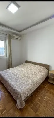a bedroom with a bed in a room with a window at Aprtmani centar 2 in Ulcinj