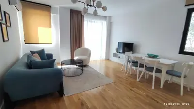 a living room with a couch and a table and chairs at Apartments LORA in Bonila in Rafailovici