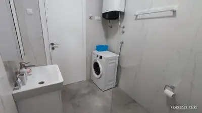 a bathroom with a washing machine and a sink at Apartments LORA in Bonila in Rafailovici