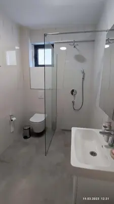a bathroom with a shower and a toilet and a sink at Apartments LORA in Bonila in Rafailovici