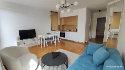 a living room with a blue couch and a table at Apartments LORA in Bonila in Rafailovici