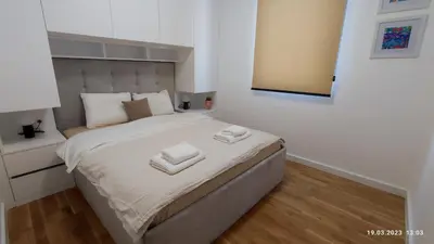 a bedroom with a bed with two towels on it at Apartments LORA in Bonila in Rafailovici