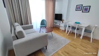 a living room with a white couch and a table at Apartments LORA in Bonila in Rafailovici
