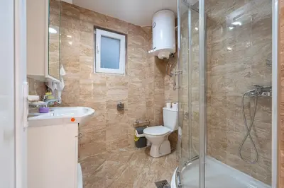 a bathroom with a shower and a toilet and a sink at Regina Residence in Budva