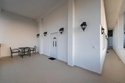 a hallway with a table and a white wall at Regina Residence in Budva