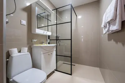 a bathroom with a toilet and a glass shower at Regina Residence in Budva
