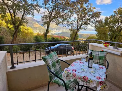 a table and chairs on a balcony with a view at GreenHill-1 Sutomore Apartm in Sutomore