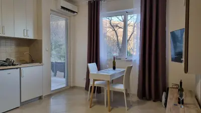 a kitchen with a table and chairs and a window at GreenHill-1 Sutomore Apartm in Sutomore