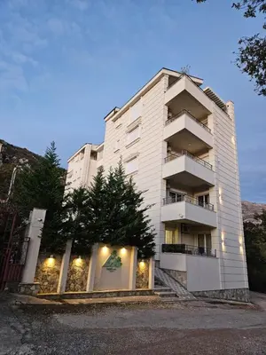 a tall white building with stairs in front of it at GreenHill-1 Sutomore Apartm in Sutomore