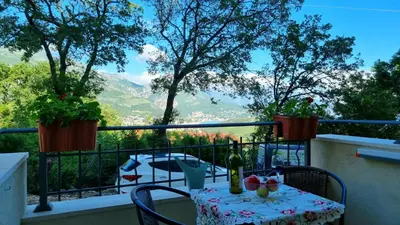 a table and chairs on a balcony with a view at GreenHill-1 Sutomore Apartm in Sutomore