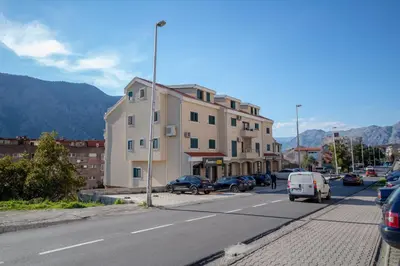 a building on the side of a street with cars parked at Lena apartment 2 in Kotor