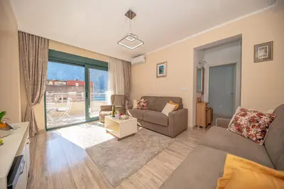 a living room with two couches and a large window at Lena apartment 2 in Kotor