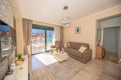 a living room with a couch and a large window at Lena apartment 2 in Kotor