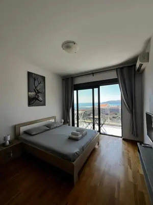 a bedroom with a bed and a large window at Paradise Apartments Becici in Becici