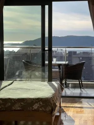 a bedroom with a bed and a view of the city at Paradise Apartments Becici in Becici