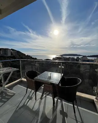 a patio with a table and chairs on a balcony at Paradise Apartments Becici in Becici