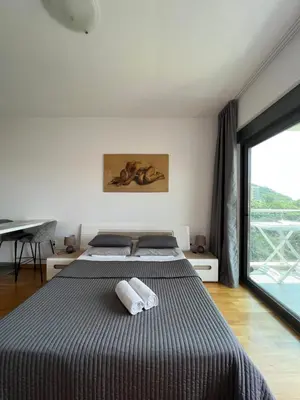 a bedroom with two beds and a large window at Paradise Apartments Becici in Becici