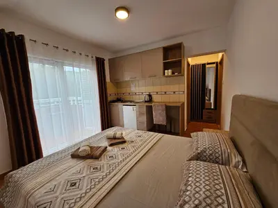 a bedroom with a large bed with two shoes on it at Dom M Apartments in Budva