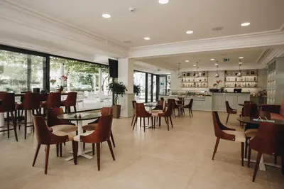 a restaurant with tables and chairs and a kitchen at Hotel Montenegro in Budva